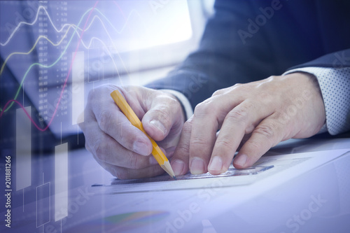 Businessman analysing business investment data with laptop computer notebook and document in the office.