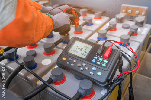 Electrical technician use milliohm meter to measure internal resistance and voltage of batteries which use at offshore oil and gas wellhead remote platform to monitor battery performance.
