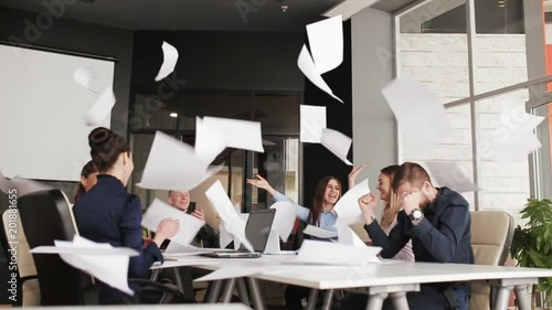 Group of business people throwing documents in air