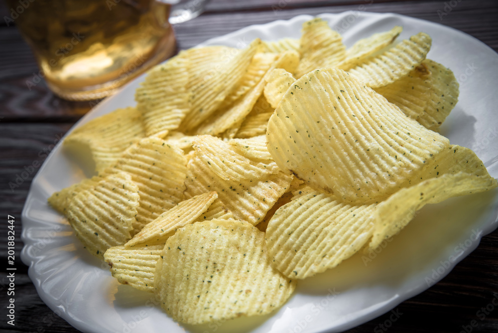 Potato chips and beer on a wooden table Potato chips and beer on a wooden table