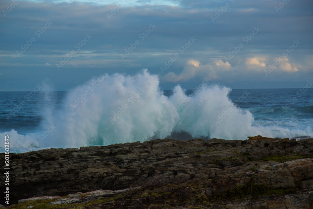 Blue waves breaking over rocks