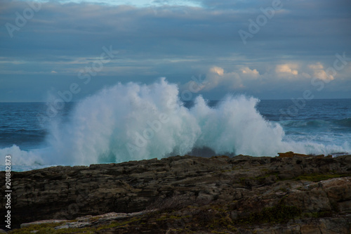 Blue waves breaking over rocks