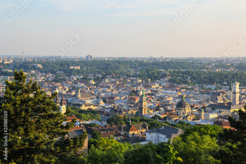Panoramic view on the old beautiful european city. Medieval architecture with churches, houses, cathedrals and roofs. Summer green photos of ancient Lviv. Amazing town scenery in evening sunset lights © Vadym