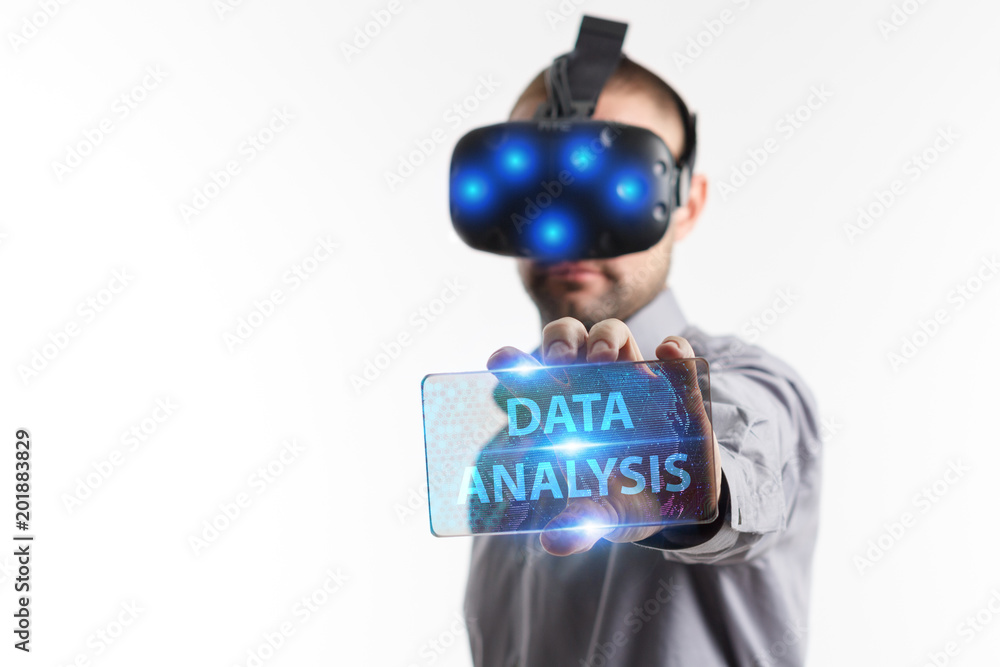 Business, Technology, Internet and network concept. Young businessman working in virtual reality glasses sees the inscription: Data analysis Business, Technology, Internet and network concept. Young businessman working in virtual reality glasses sees the inscription: Data analysis