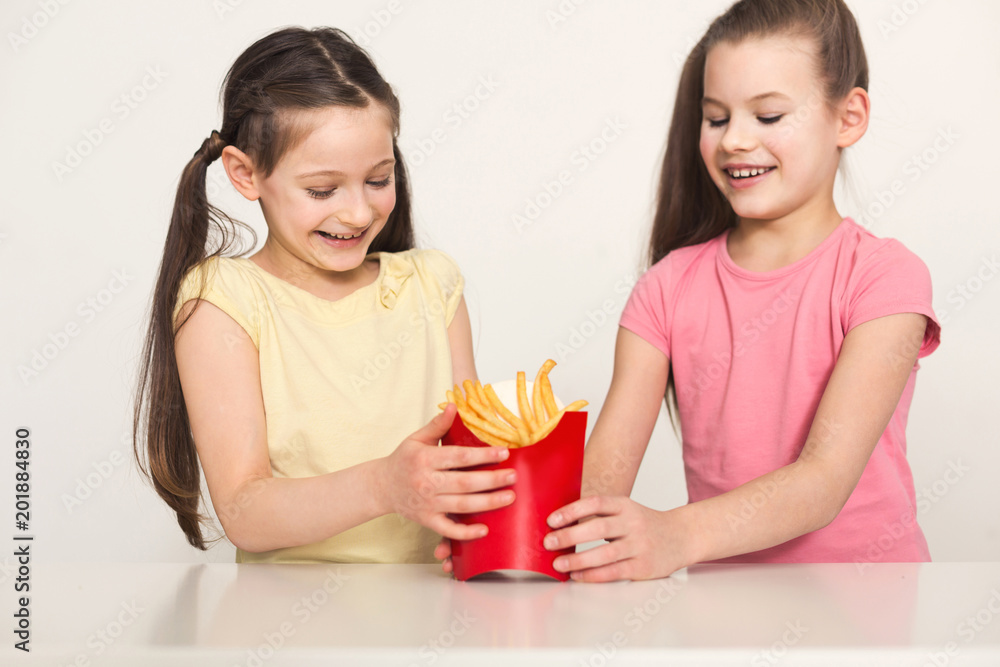 Happy little girls holding a bag of fries Happy little girls holding a bag of fries