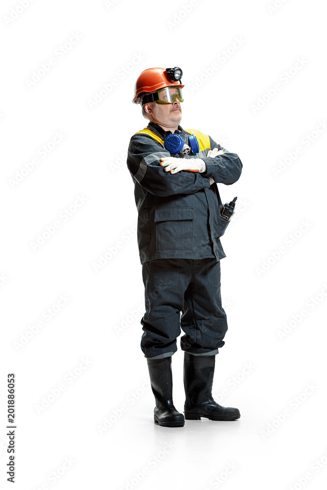 The studio shot of senior bearded male miner standing at the camera on a white background. The studio shot of senior bearded male miner standing at the camera on a white background.
