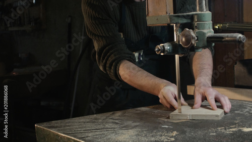 middle field on a carpenter who cuts a piece of wood with a band saw