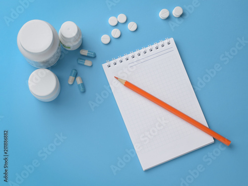 Tablets, capsules and notepad with a pencil. Concept prescription, dosage, overdose, planning.