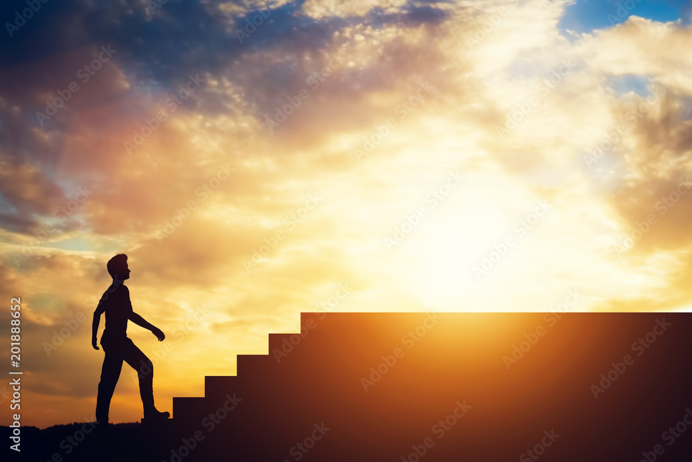 Silhouette of a man standing in front of stairs.