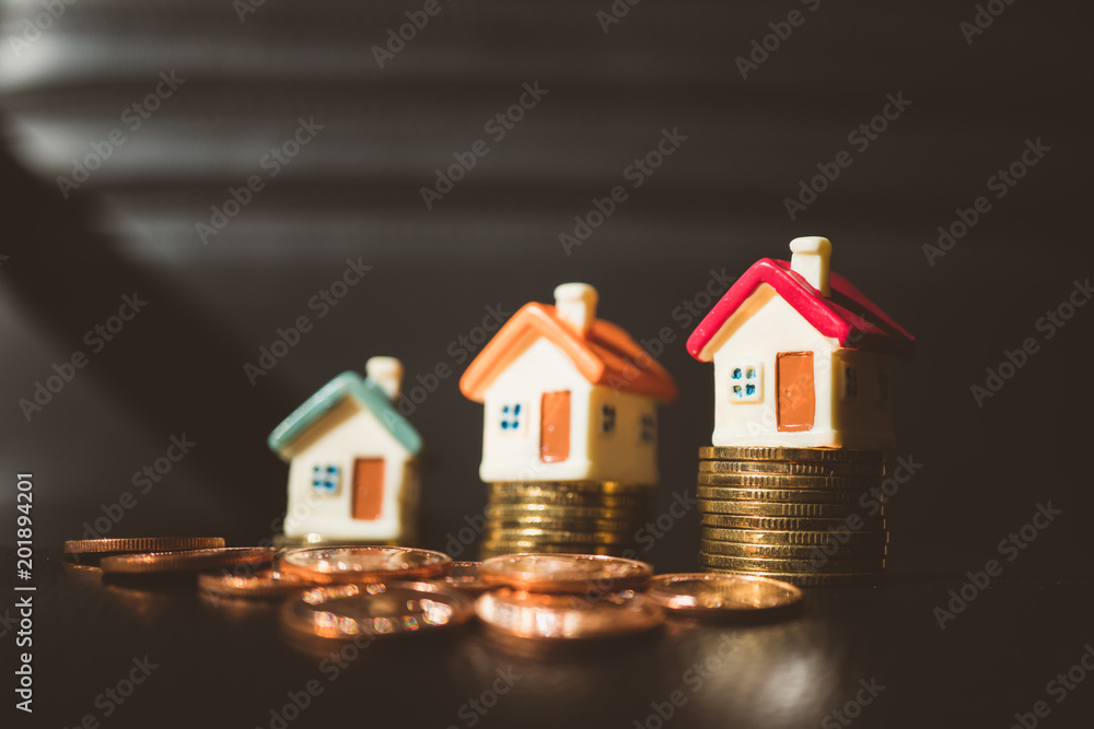 Miniature colorful houses with stack coins on dark background using as property and business concept - Vintage filter Miniature colorful houses with stack coins on dark background using as property and business concept - Vintage filter