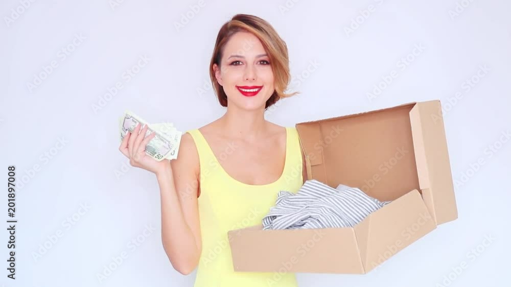 Young redhead girl holding box with dress bought in Internet store via online Young redhead girl holding box with dress bought in Internet store via online