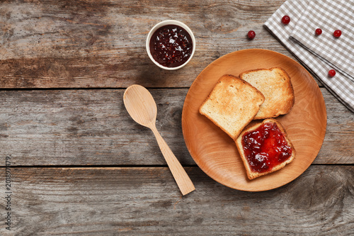 Toasts with sweet jam on wooden background, flat lay composition