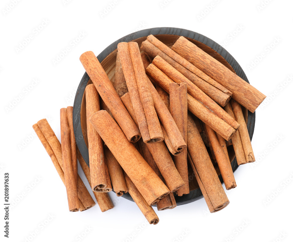 Bowl with aromatic cinnamon sticks on white background Bowl with aromatic cinnamon sticks on white background