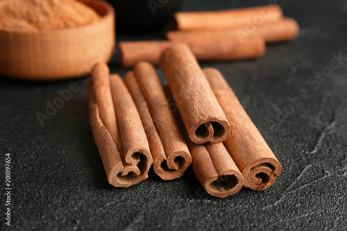Aromatic cinnamon sticks on dark grey background, closeup