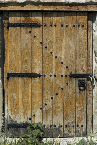 Old wooden door in stone wall with padlock. Architect textured background