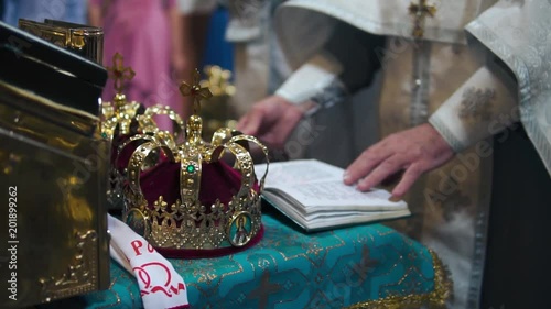 the wedding ceremony in the Christian church, the crown on the altar, the priests read the prayer from the bible, slow-motion shooting, smooth movement, camera slide, concept sacred rituals,