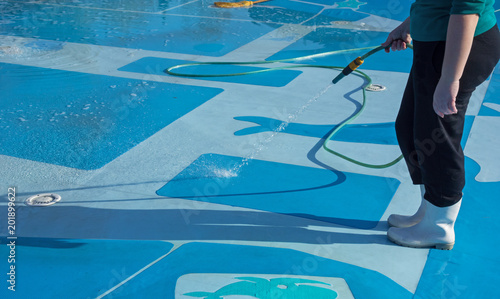 worker cleans the bottom of a large pool