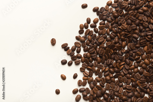 Heap of brown coffee beans isolated on white © Prostock-studio