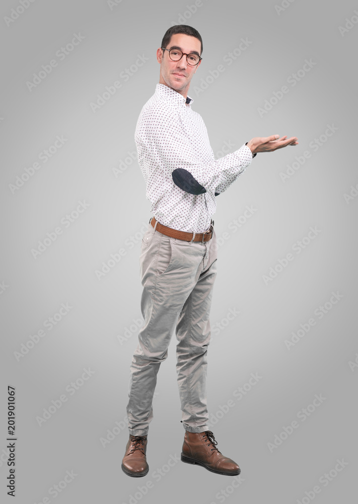 Concept of a young man showing something with his hands - Full body shot Concept of a young man showing something with his hands - Full body shot