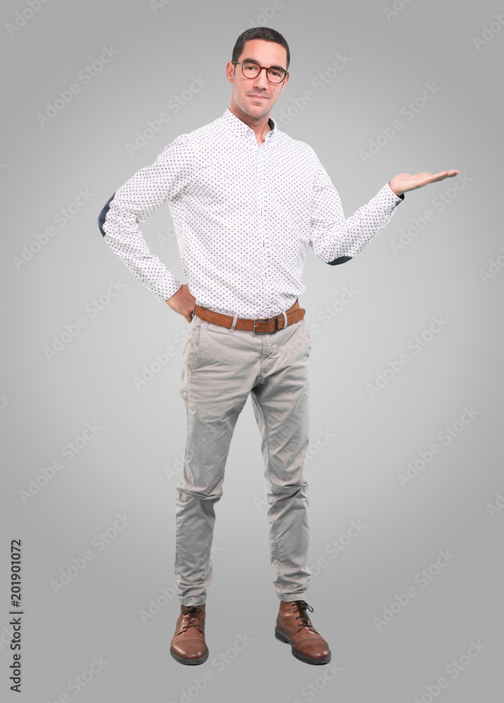 Concept of a young man showing something with his hands - Full body shot Concept of a young man showing something with his hands - Full body shot