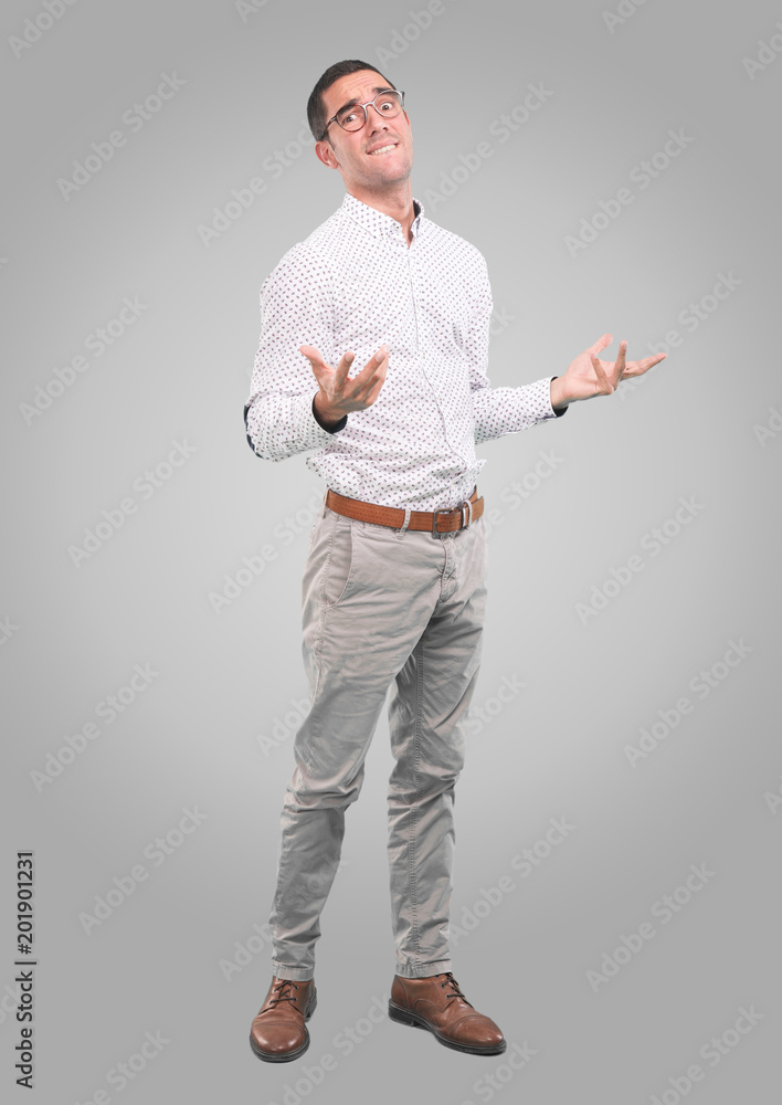 Concerned young man with a gesture of mercy - Full body shot