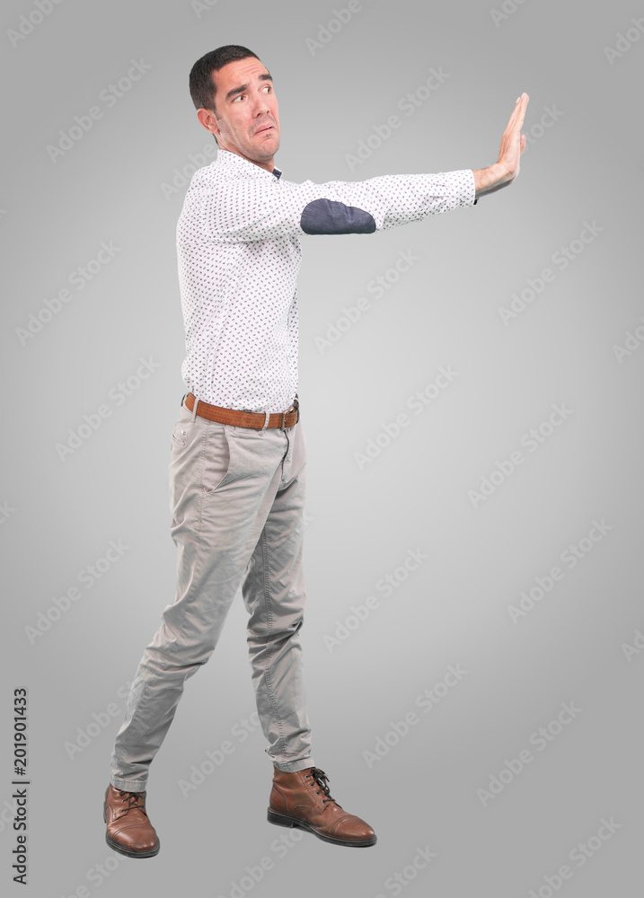 Concerned young man with a gesture of hold - Full body shot Concerned young man with a gesture of hold - Full body shot