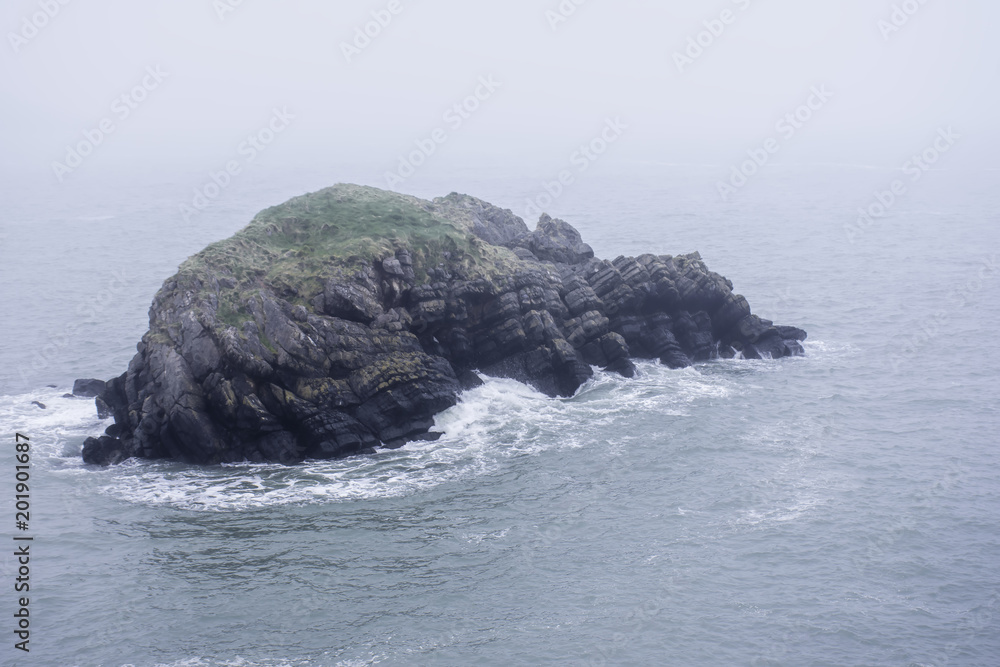Rocky isle on misty sea Rocky isle on misty sea