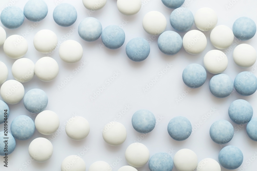 White and blue pills on light surface