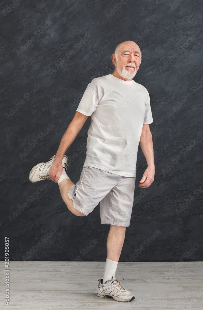 Senior man stretching legs indoors
