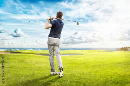 Fotografía Junger Golfspieler spielt auf Golfplatz am Meer