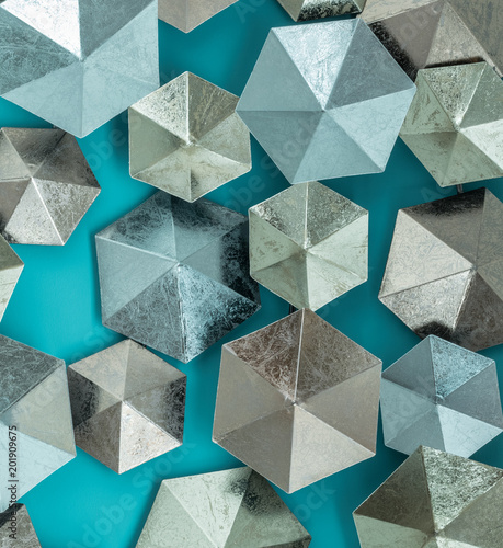 modern contemporary composition of colourful hexagonal shaped plates from rough textured metal on aqua background