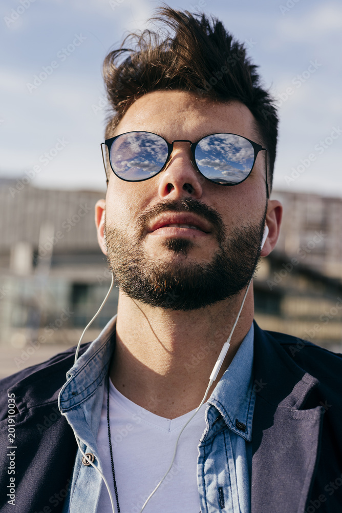Stylish man relaxing with music on seafront
