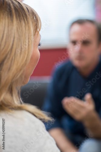 Rear View Of Depressed Mature Woman Talking To Counselor