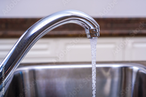 Kitchen tap with water flowing