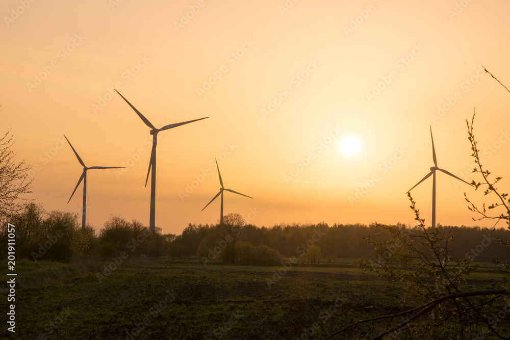 windmills in a farmland during sunset windmills in a farmland during sunset