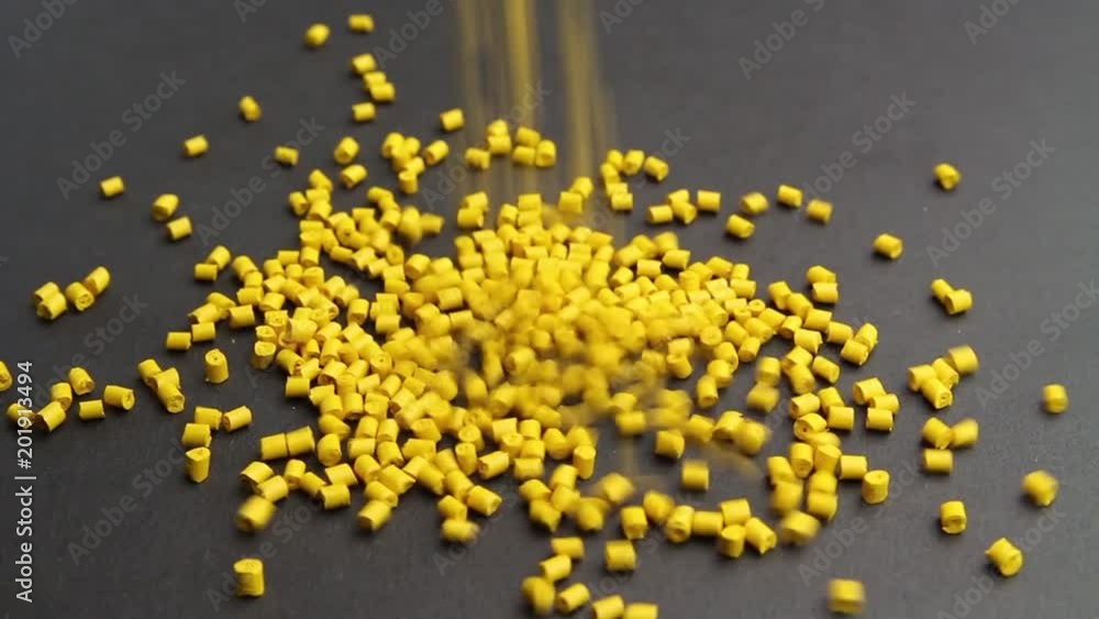 Plastic pellets crumbles to the table . Plastic raw materials in granules for industry. Polymer resin. Plastic pellets crumbles to the table . Plastic raw materials in granules for industry. Polymer resin.