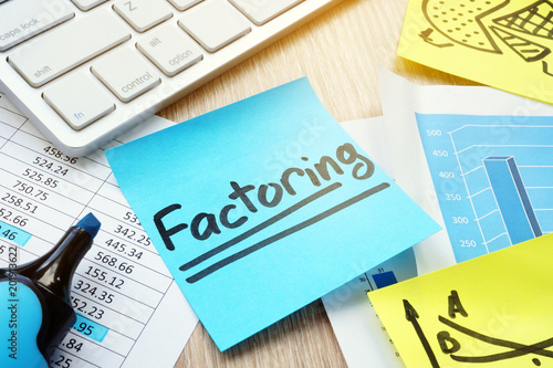 Stick with word factoring on a desk. Factor concept. photo
