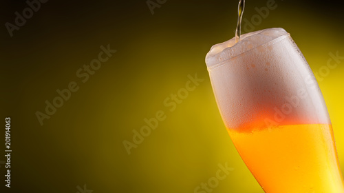 Cold light Beer in a glass with water drops.