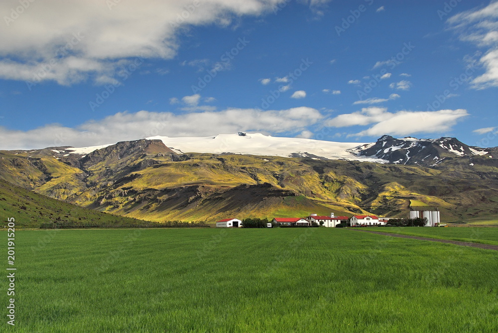 Iceland. Cozy cottages at the foot of graceful mountains