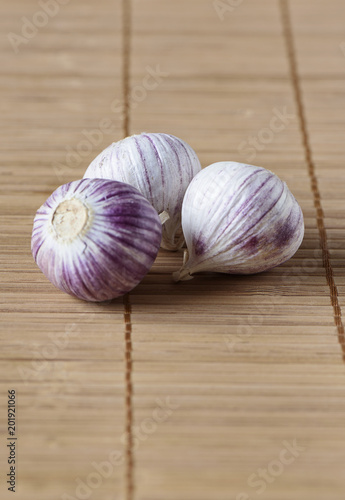 Three bulbs of garlic on a mat