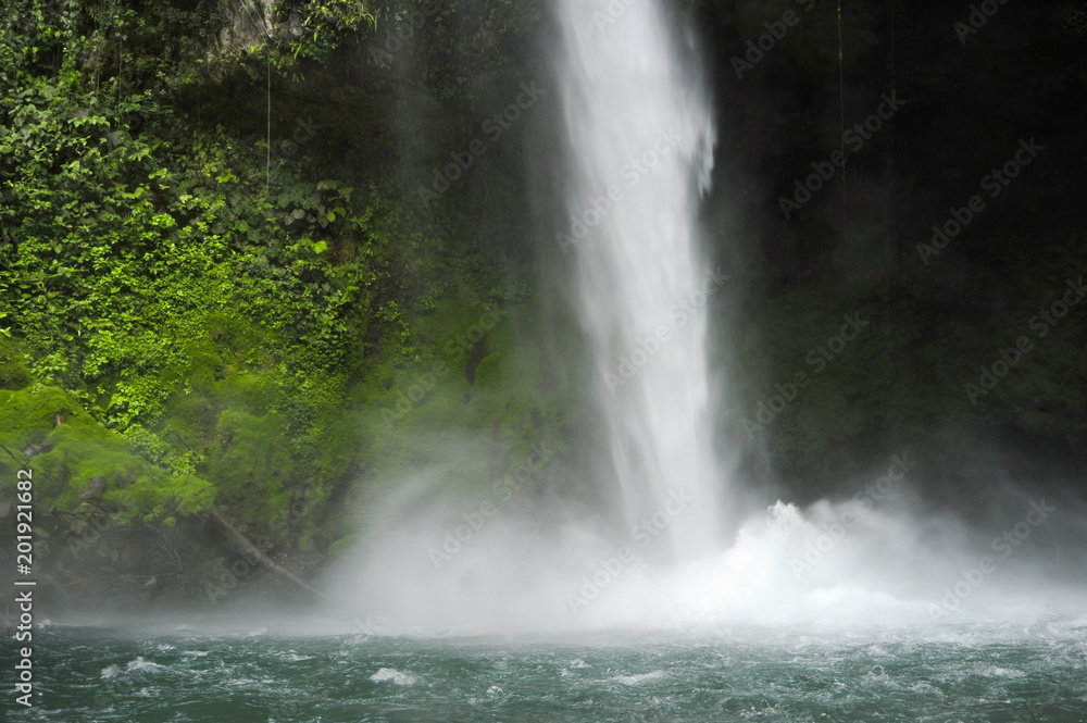 La Fortuna Waterfall pounds down to create a cooling mist. La Fortuna Waterfall pounds down to create a cooling mist.