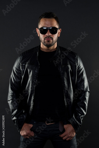 Brutal macho in leather jacket. Bearded man in fashion sunglasses. Mens sexuality and attraction. Fashion model in sunglasses. Man with beard has stylish look. Musuclar athlete in trendy clothes