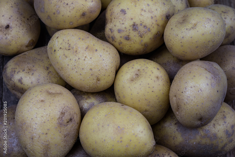 Tasty potatoes on a wooden table. Vegetables on the kitchen table in a jute sack. Tasty potatoes on a wooden table. Vegetables on the kitchen table in a jute sack.