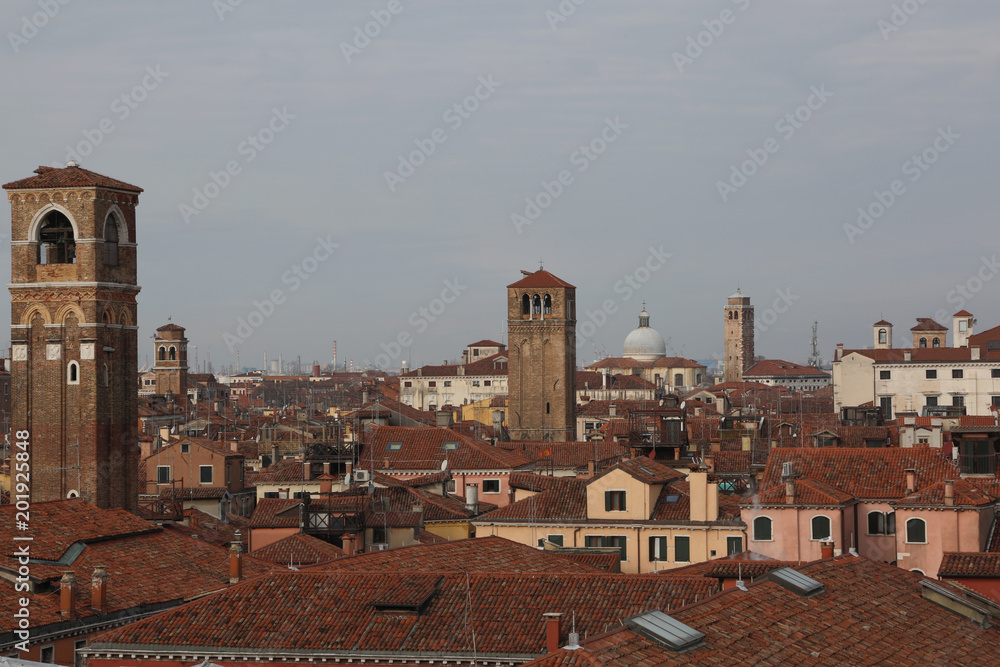 red brick roofs of houses, and church bell towers of an Italian