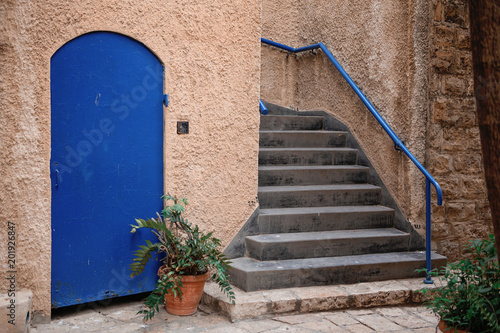 Narrow ancient streets of the old city Yaffo Israel in the magic sunset light. Vintage door with green plant. Tavel Meadle East photo