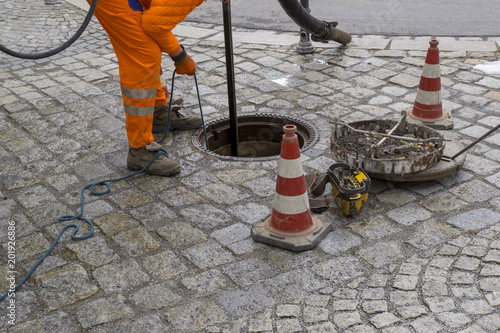 Tableau sur toile sewerage worker on street cleaning pipe