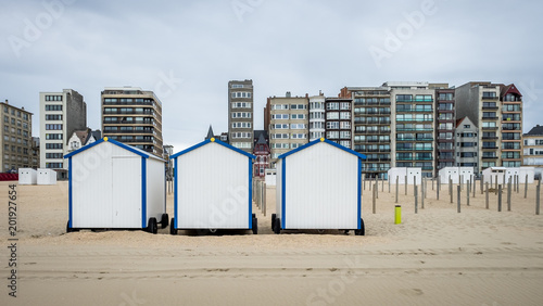 Row of vintage beach huts with buildings in the background photo