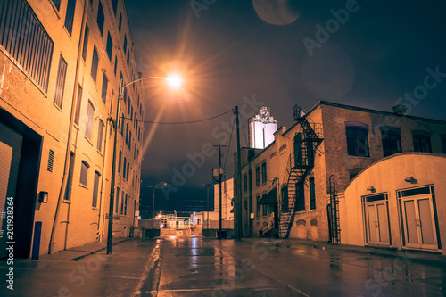 Industrial urban street city night scenery in Chicago with vintage warehouses and factories after a rain.