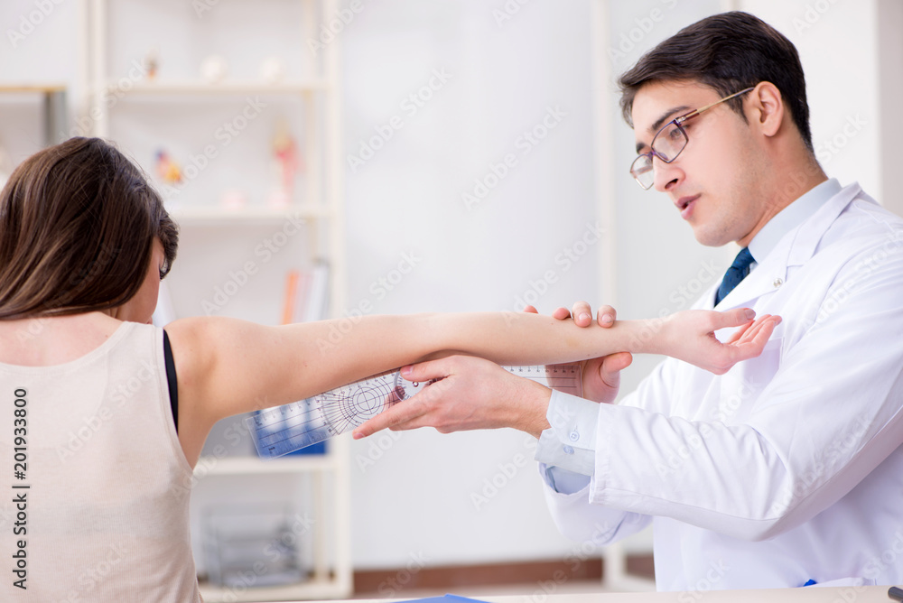 Doctor checking patients joint flexibility with gonimeter Doctor checking patients joint flexibility with gonimeter