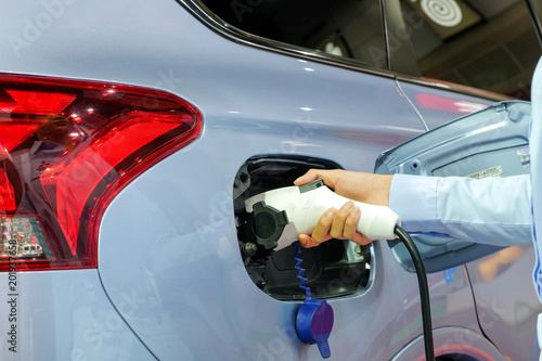 Φωτογραφία Close-up asia women hands who are fueling a new vehicle electrification via rechargeable electricity machine, Electric cars are a new innovation in the future, built to replace cars powered by oil